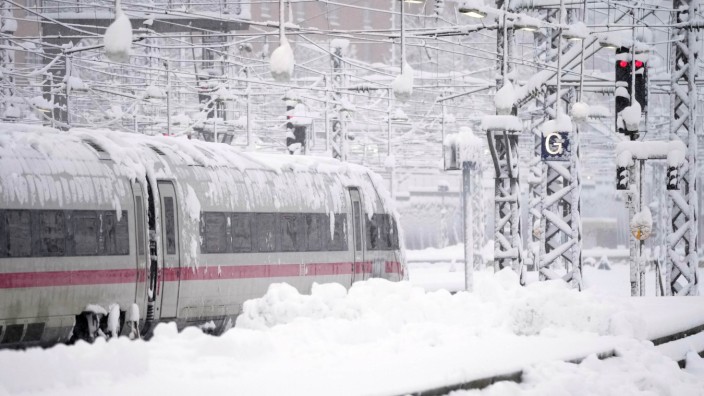 Live blog: An ICE train is parked at Munich Central Station after heavy snowfall.  Snow and ice have caused chaos on the roads and railways in southern Bavaria.