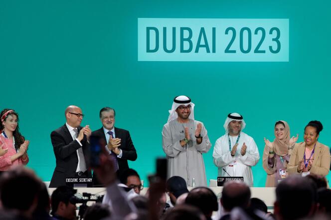 COP28 President Sultan Al-Jaber (center) applauds among other officials, December 13, 2023, in Dubai.