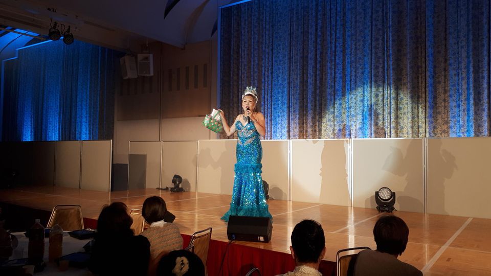 Maria Akasaka is transgender and usually delights her audience at dinner shows with musical numbers, sparkly clothing and lots of humor.  Now she would like to become mayor