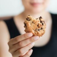 Woman holds a cookie in her hand.