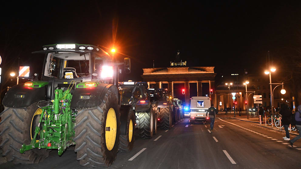 Dozens of tractors were parked on the street at the Brandenburg Gate late Sunday evening
