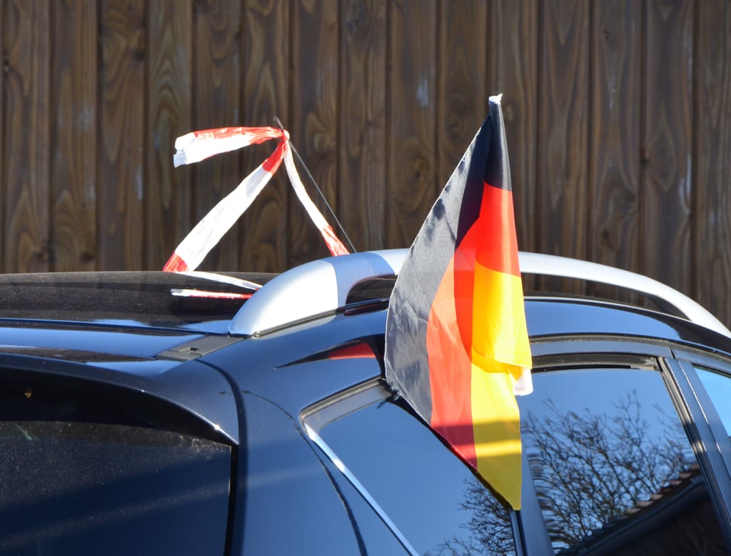 Auf einem Auto in Seehausen wehen ein Flatterband und die Deutschlandflagge.