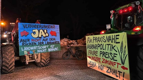 Two tractors with protest posters at night.  © NDR Photo: Maren Osterbuar