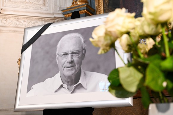 January 10, 2024, Bavaria, Munich: Football: A portrait of Franz Beckenbauer can be seen next to a bouquet of white roses in the court chapel of the Residenz.  Beckenbauer died on Sunday, January 7th, 2024 at the age of ...