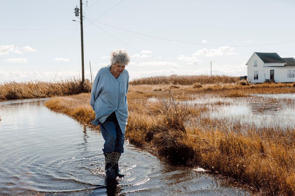 Brenda Laird walks through the standing water on the street