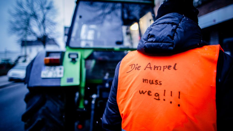 Farmers' protest: A man wears a high-visibility vest that says: "The traffic lights have to go"