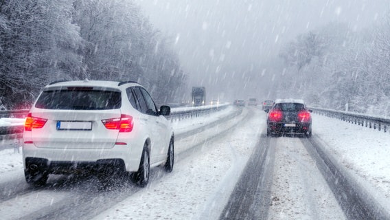 Cars drive on a snowy road in blowing snow.  © fotolia Photo: petair