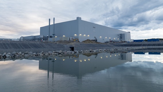A factory hall stands near a body of water.  © Northvolt Photo: Northvolt