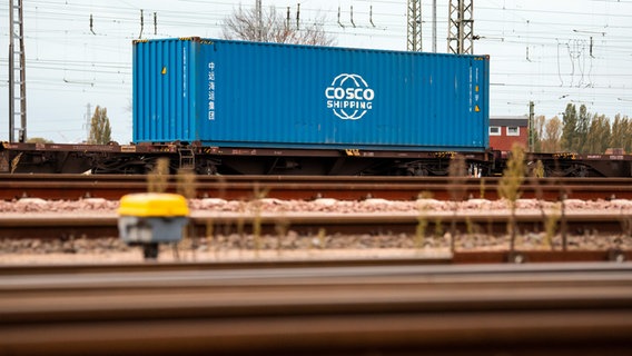 A blue container sits on a freight truck in the port.  © picture alliance/dpa Photo: Daniel Bockwoldt