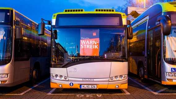 Buses are parked at a depot of the Hanover transport company Üstra - the lettering is on a poster "Warning strike today" to read.  © picture alliance/dpa Photo: Moritz Frankenberg