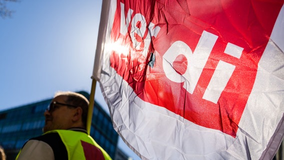 A participant in a warning strike rally holds a ver.di flag.  © picture alliance/dpa |  Christoph Soeder Photo: Christoph Soeder