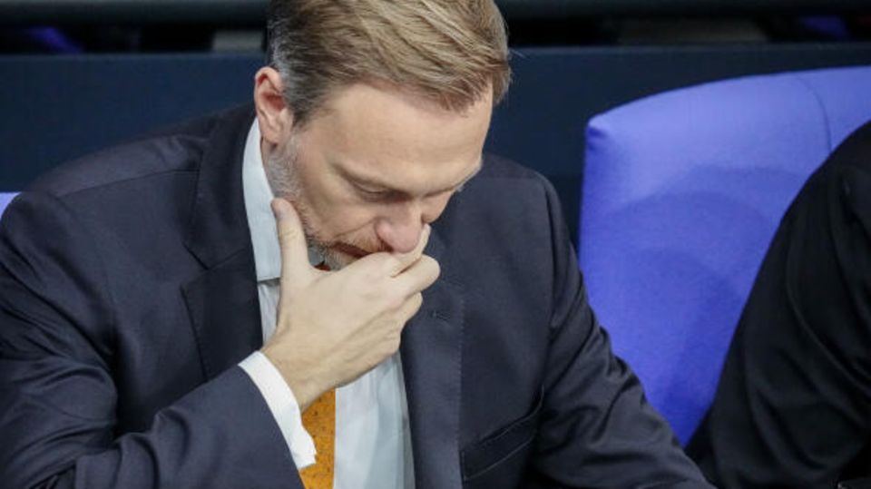 Christian Lindner from the FDP holds his hand in front of his face