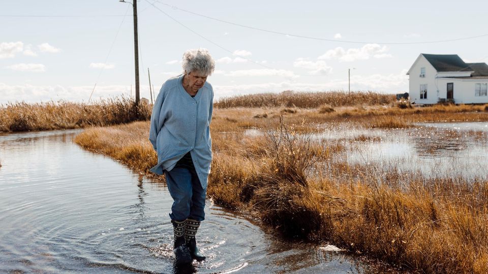 Brenda Laird walks through the standing water on the street