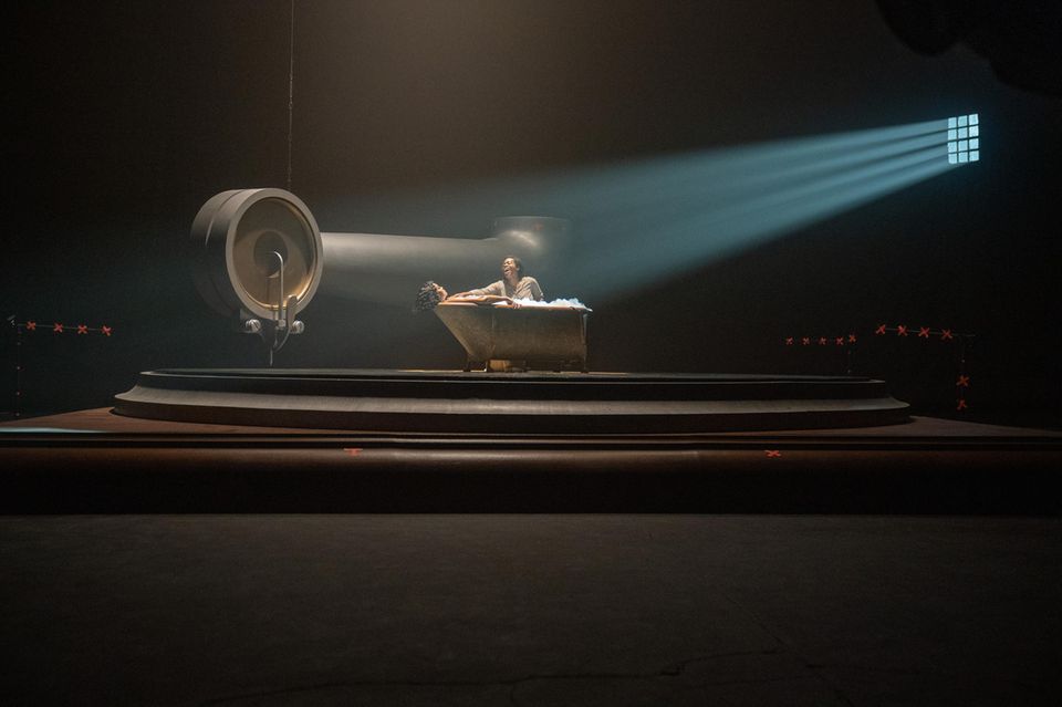 Film scene shows two women on a stage in a bathtub