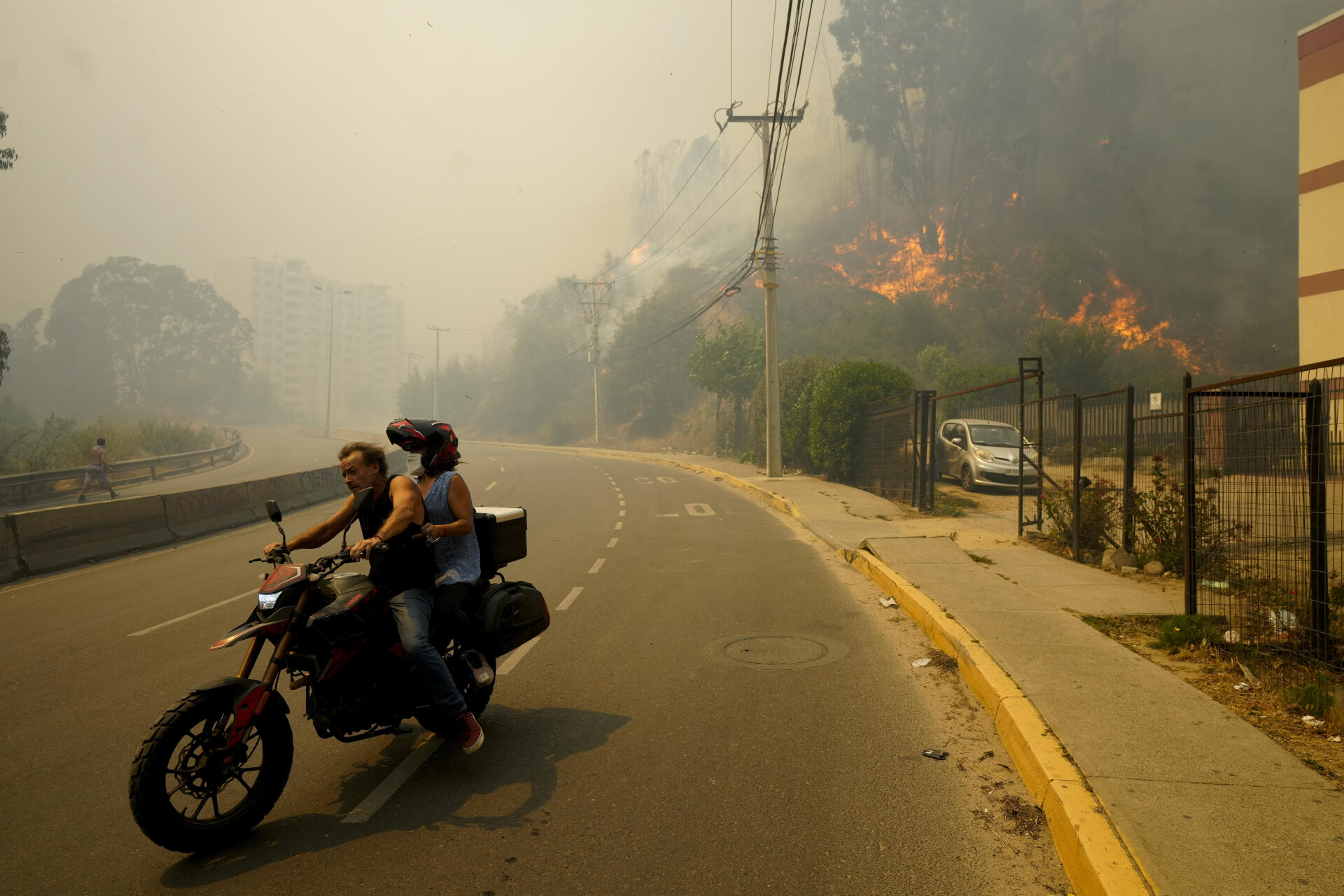 Residents evacuate on motorbikes, in Vina del Mar, Chile, Saturday February 3, 2024.