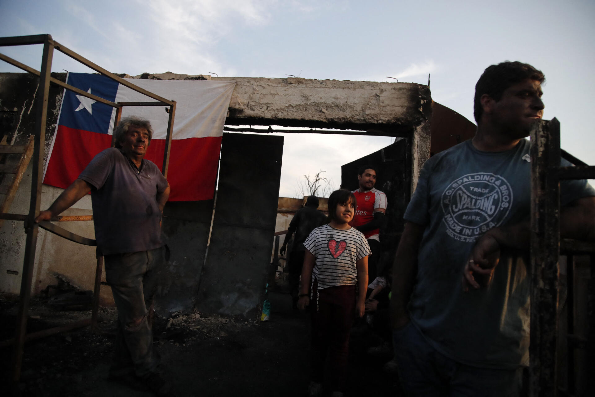 People clean a house destroyed by a forest fire in Villa Independencia, Valparaiso region, Chile, February 4, 2024.