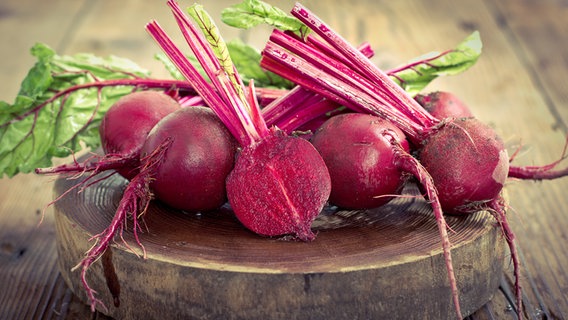 Fresh beetroot tubers on a thick wooden board.  © Fotolia.com Photo: pilipphoto
