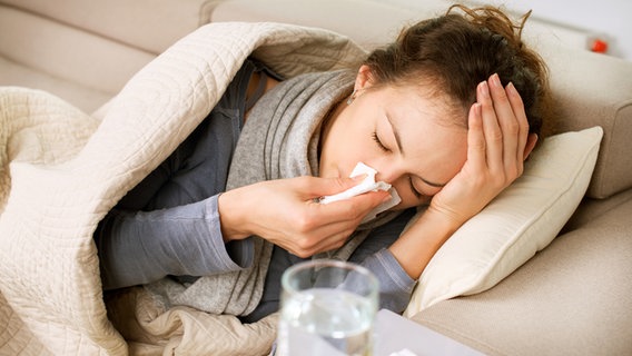 Sick woman lying on a sofa and blowing her nose © Fotolia Photo: Subbotina Anna