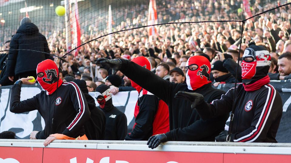 Fans of VfB Stuttgart happily throw tennis balls