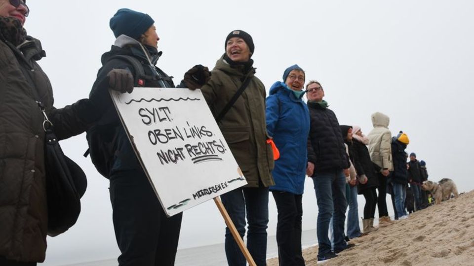 Locals and holiday guests take part in an initiative human chain on the beach on Sylt "Sylt against the right" part.  Photo: Leah