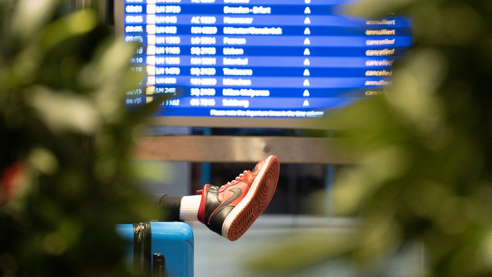 A traveler lies on a bench at Frankfurt Airport