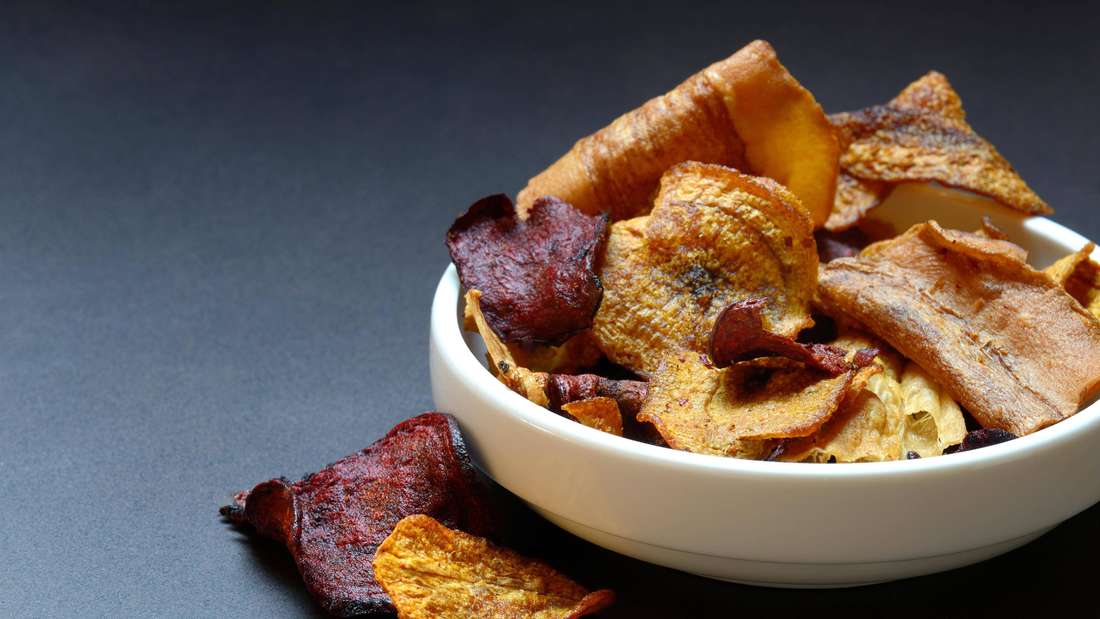 Vegetable chips in a bowl consisting of carrots, beetroot and parsnips.