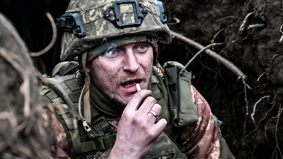 A Ukrainian soldier smokes in the trenches