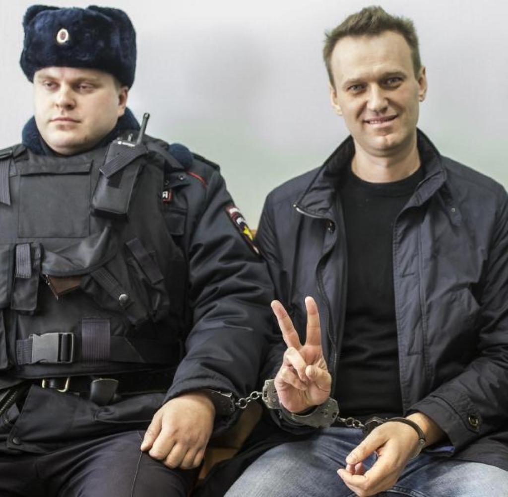 Unbeugsam: Alexej Nawalny sitzt 2021 neben einem Sicherheitsbeamten im Gericht und macht das Victory-Zeichen