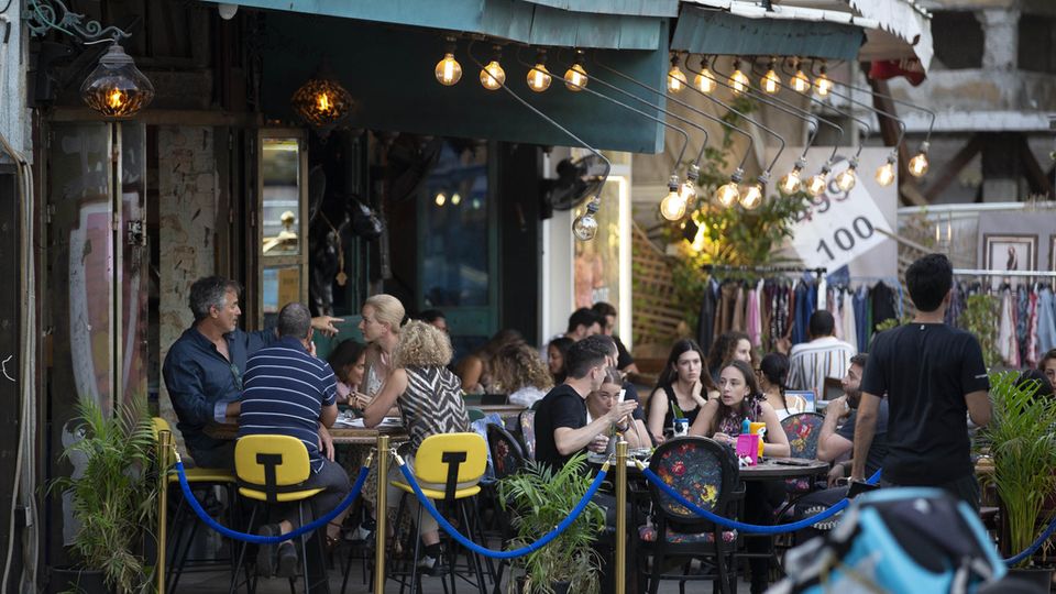 People enjoy their time in a cafe: Wearing masks is no longer required in Israel after a drop in infection rates in Tel Aviv