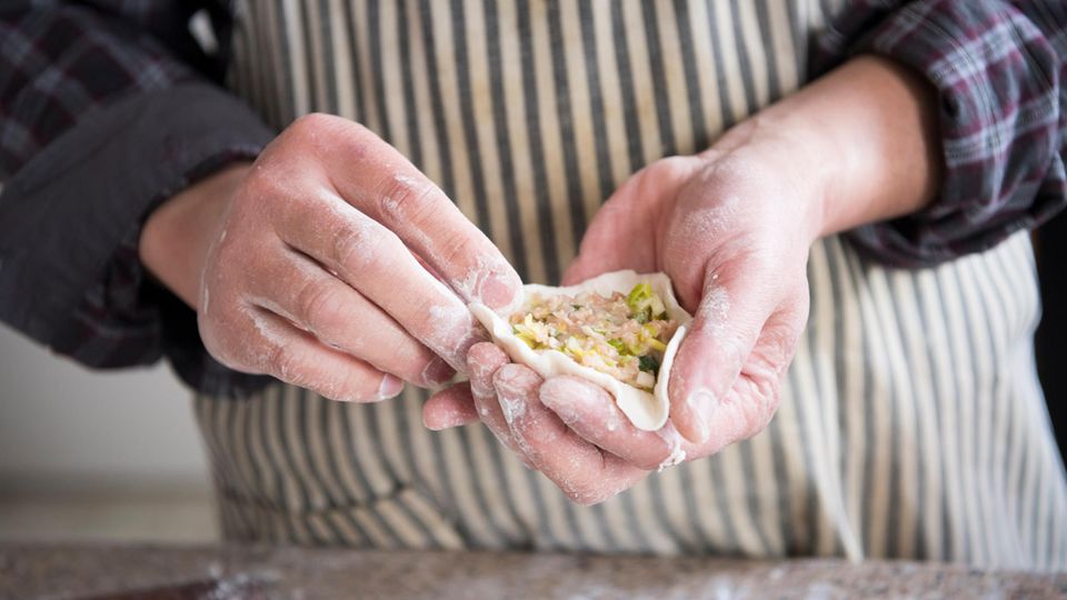 Hold dumplings in your hand and fill them with minced meat