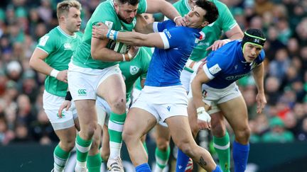 Irish center Robbie Henshaw tackles the Italian defender during the Six Nations Tournament match between Ireland and Italy on February 11, 2024 in Dublin (Ireland).  (PAUL FAITH / AFP)