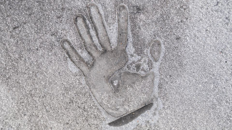 Handprint of a climate activist who has superglued himself to the street