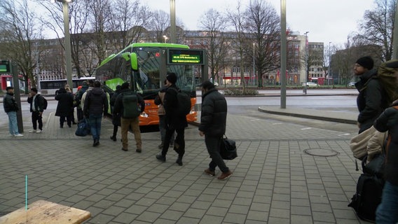 Travelers are queuing in front of a long-distance bus from Flixbus at the bus station in Hamburg.  © Screenshot 