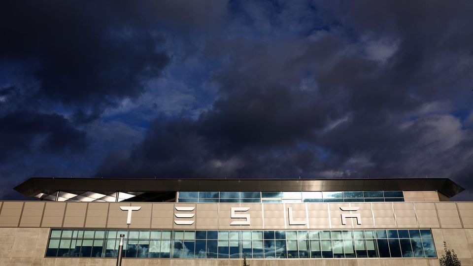 The Tesla lettering on the factory in Grünheide under a cloudy sky