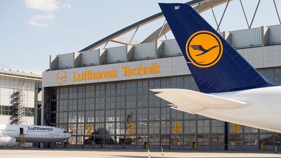 A Lufthansa Airbus A330-343 stands in front of a Lufthansa Technik AG hall in Hamburg.  © picture alliance / dpa Photo: Daniel Reinhardt