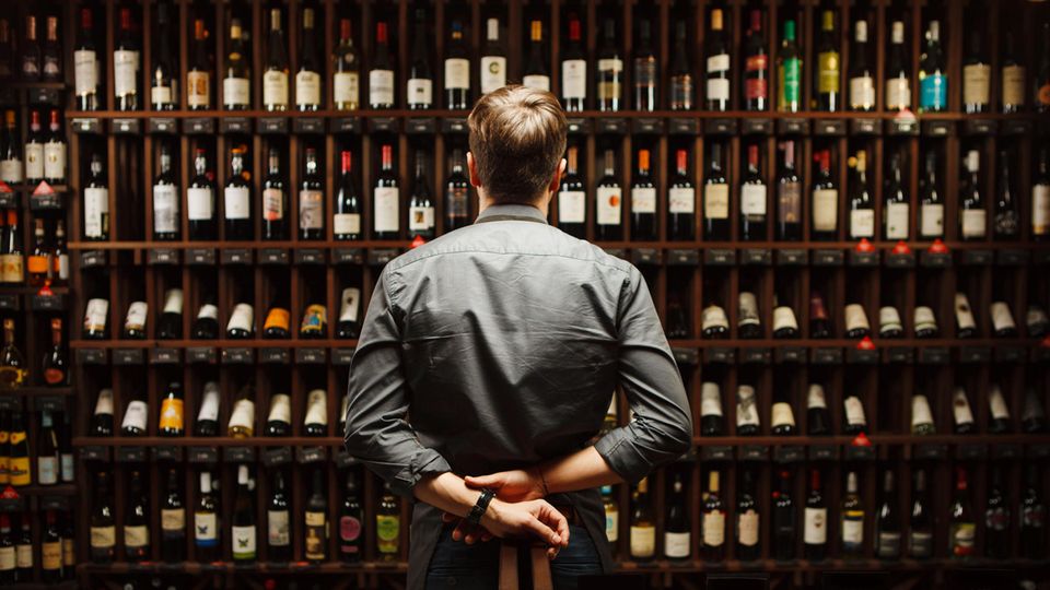 Man stands in front of wine rack