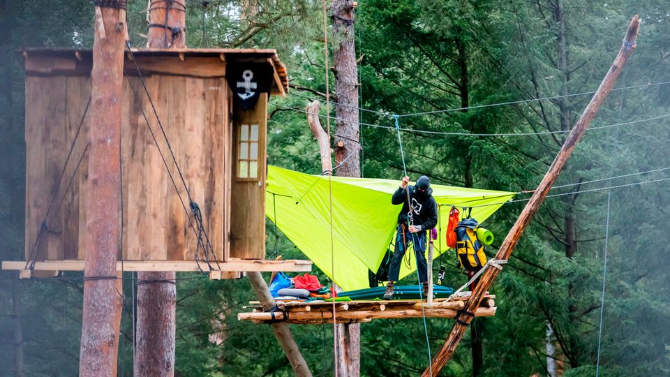 An activist ropes in the initiative's camp "Stop Tesla" in the pine forest near the Tesla Gigafactory