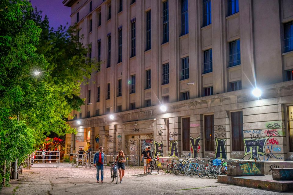 People walk in front of Berghain in Berlin at night and make their way home