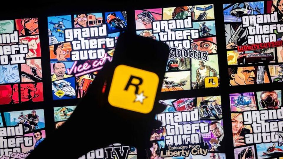 Rockstar Games logo on a smartphone screen and cover of the Grand Theft Auto video game series