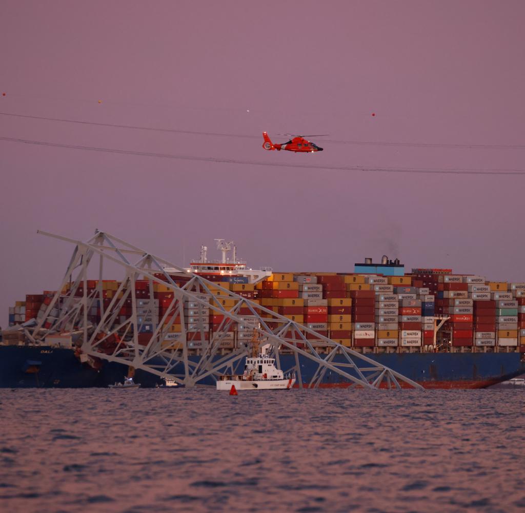 The morning after the collision: A rescue helicopter over the container freighter that caused the bridge to collapse.