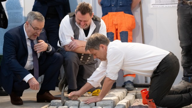 Craft fair: Robert Habeck (right) lets instructor Heinz Dotzauer (center) show him how to lay paving stones.  Crafts president Jörg Dittrich (left) looks on.