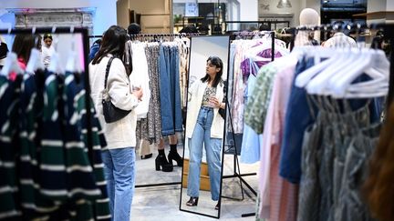 A customer tries on clothes from the Shein brand, in Paris, May 4, 2023. (CHRISTOPHE ARCHAMBAULT / AFP)