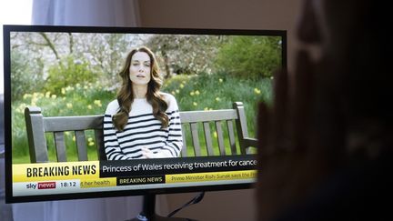 A person watches the video of Kate Middleton announcing she has cancer, on the Sky News channel in London on March 22, 2023. (RASID NECATI ASLIM / ANADOLU / AFP)