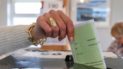 An Irish woman casts a ballot on the island of Gola, in western Ireland, on March 8, 2024. (PAUL FAITH / AFP)